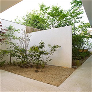 ポーチと中庭の間には白い壁を設けて、小さな前庭としています。